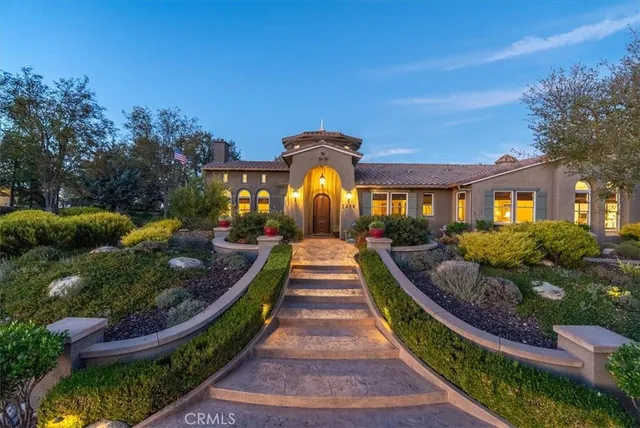 a view of a backyard with table and chairs under a large tree