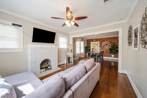 a living room with furniture a fireplace and a flat screen tv