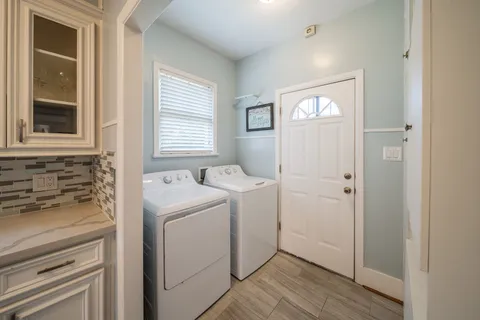 a view of washer and dryer with bathroom in the background
