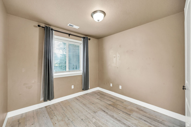 778 South 650 West Logan, UT 84321 - Photo 21 of 26 Bdrm 3 Room featuring wood-finish flooring, a window with blinds, and a semi-flush mount ceiling light