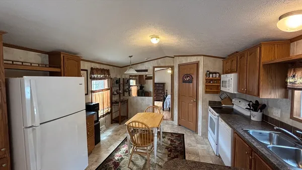 a kitchen with stainless steel appliances a refrigerator a sink a stove a table and chairs