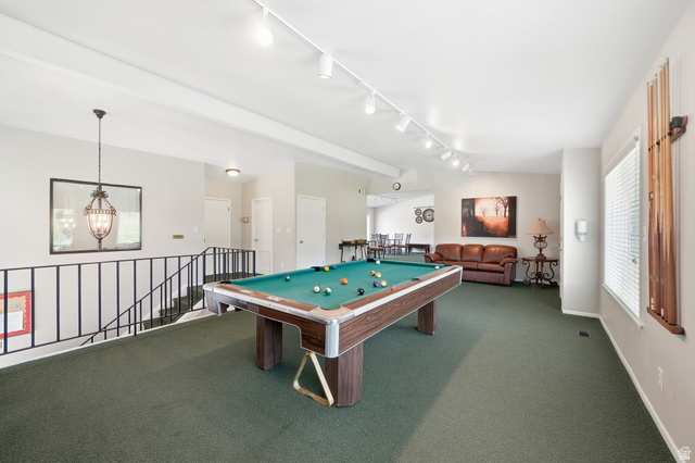 6969 South 855 East Midvale, UT 84047 - Photo 45 of 55 Spacious recreational room featuring a billiards table, track lighting, neutral wall tones, green carpeting, and a wrought iron railing