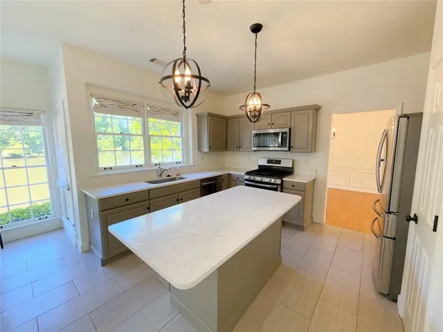 a kitchen with stainless steel appliances a stove a refrigerator and a sink