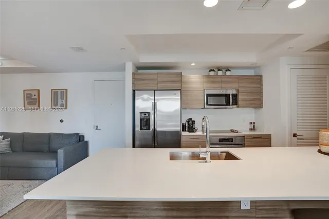 a kitchen with kitchen island a sink and a refrigerator