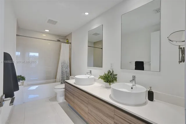 a bathroom with a double vanity sink and a mirror