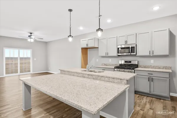 a kitchen with kitchen island a stove a sink a center island and a window