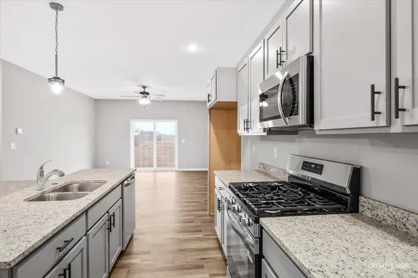 a kitchen with stainless steel appliances granite countertop a sink stove and cabinets