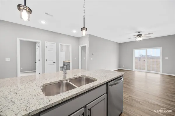a kitchen with granite countertop a sink a counter top space and living room area