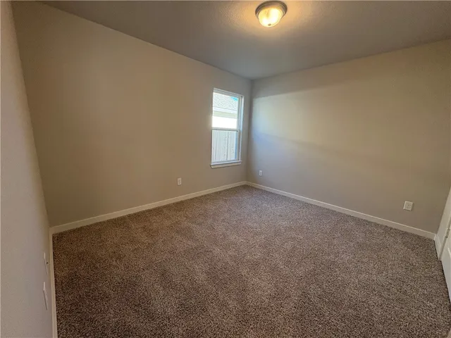an empty room with a ceiling fan and window