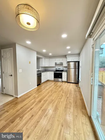 a view of empty room with wooden floor and window
