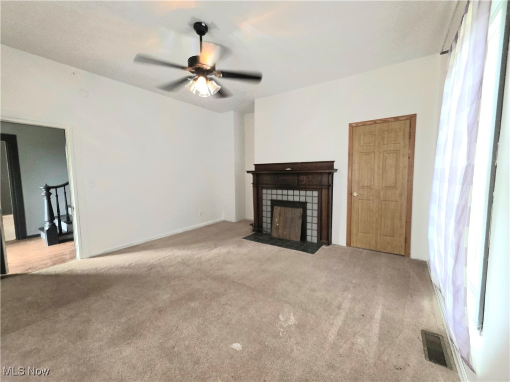 10 Browns Ridge Road Rockport, WV 26169 - Photo 11 of 35 Unfurnished living room with carpet flooring, ceiling fan, and a fireplace