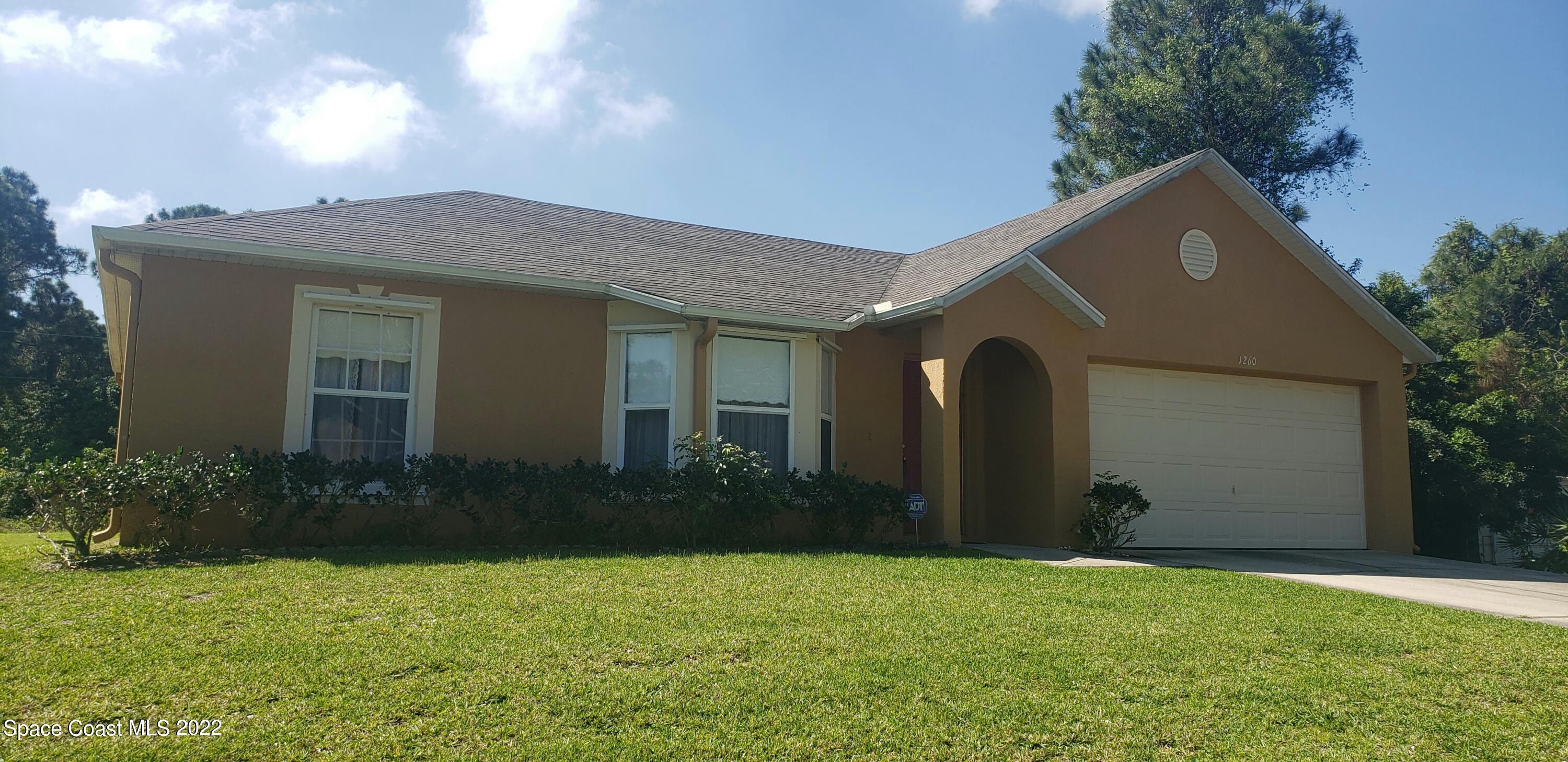 1260 Daton Road Southwest Palm Bay, FL 32908 - Photo 1 of 17 a front view of house with yard and trees in the background