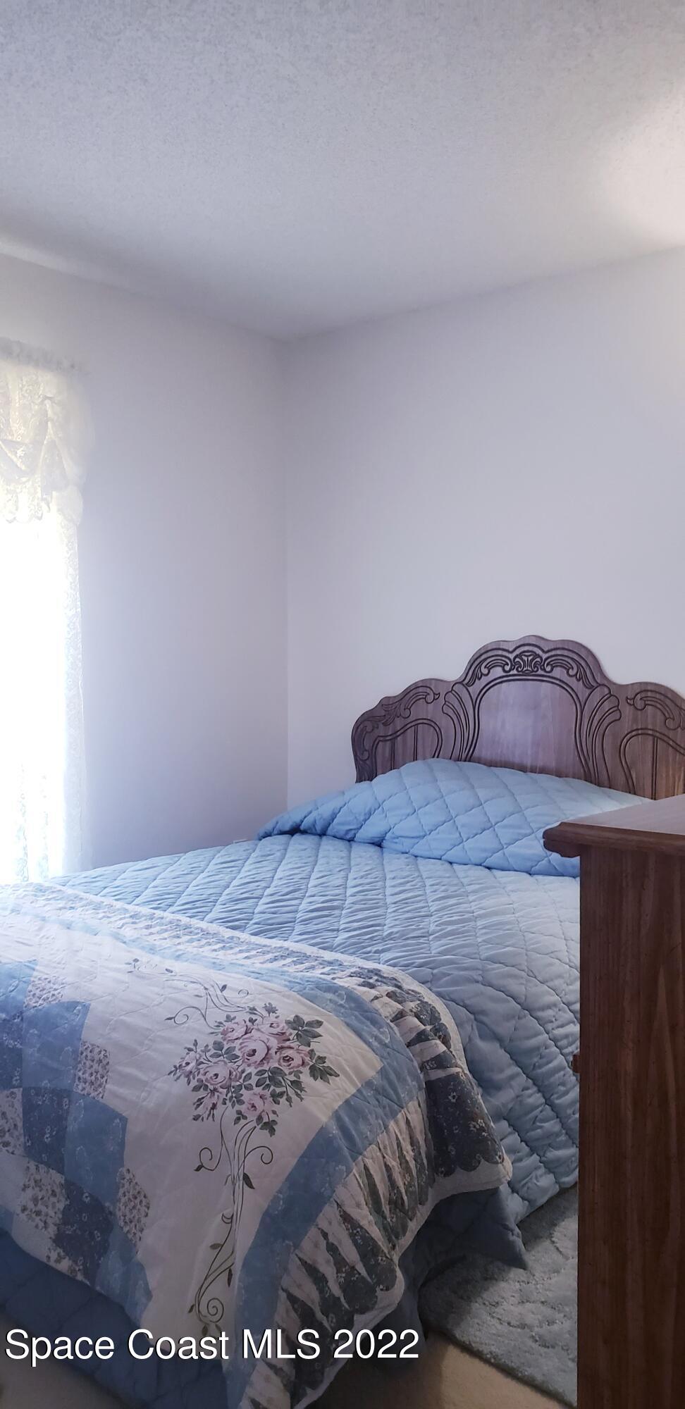 1260 Daton Road Southwest Palm Bay, FL 32908 - Photo 13 of 17 a bedroom with a bed and a night stand
