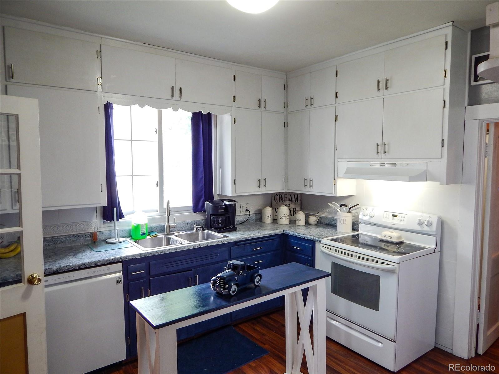 910 South Main Street Lamar, CO 81052 - Photo 9 of 37 a kitchen with stainless steel appliances sink stove and white cabinets