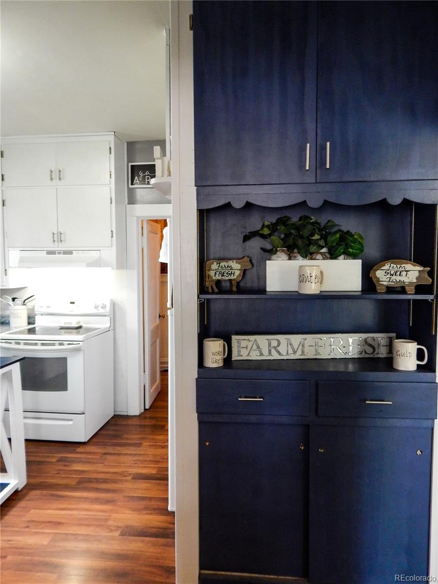 910 South Main Street Lamar, CO 81052 - Photo 10 of 37 a kitchen with stainless steel appliances granite countertop wooden cabinets a stove a sink and a hard wood floors