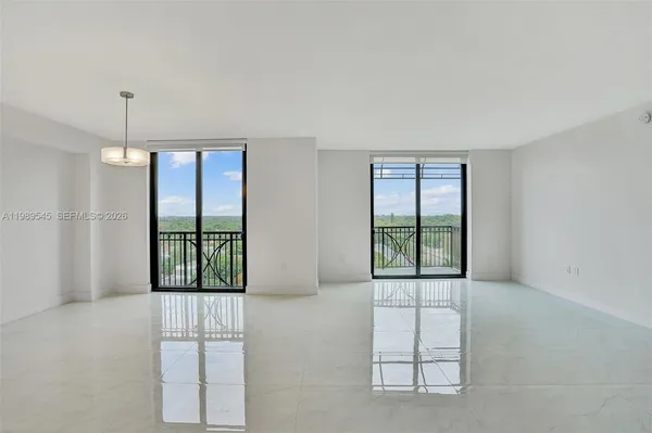 an empty room with windows and chandelier