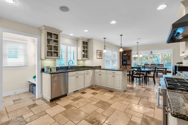 a kitchen with stainless steel appliances kitchen island granite countertop a refrigerator and a sink