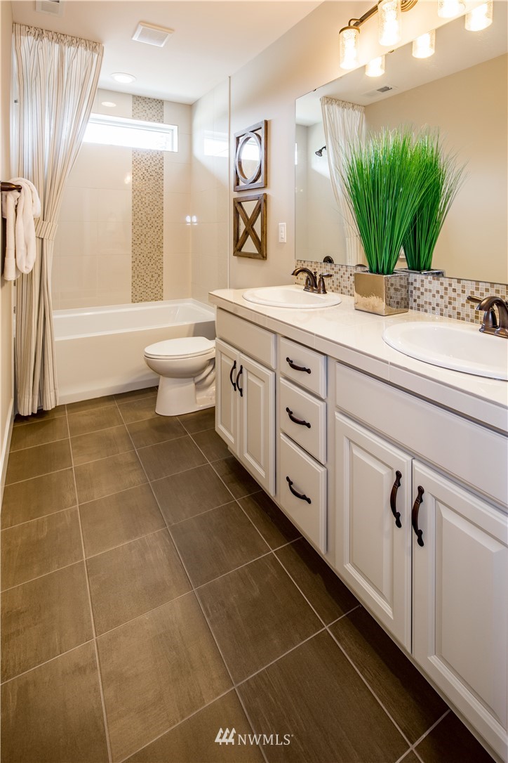 20 215th Street Southeast, Unit 12 Bothell, WA 98021 - Photo 22 of 22 a bathroom with a granite countertop sink a mirror and a bathtub