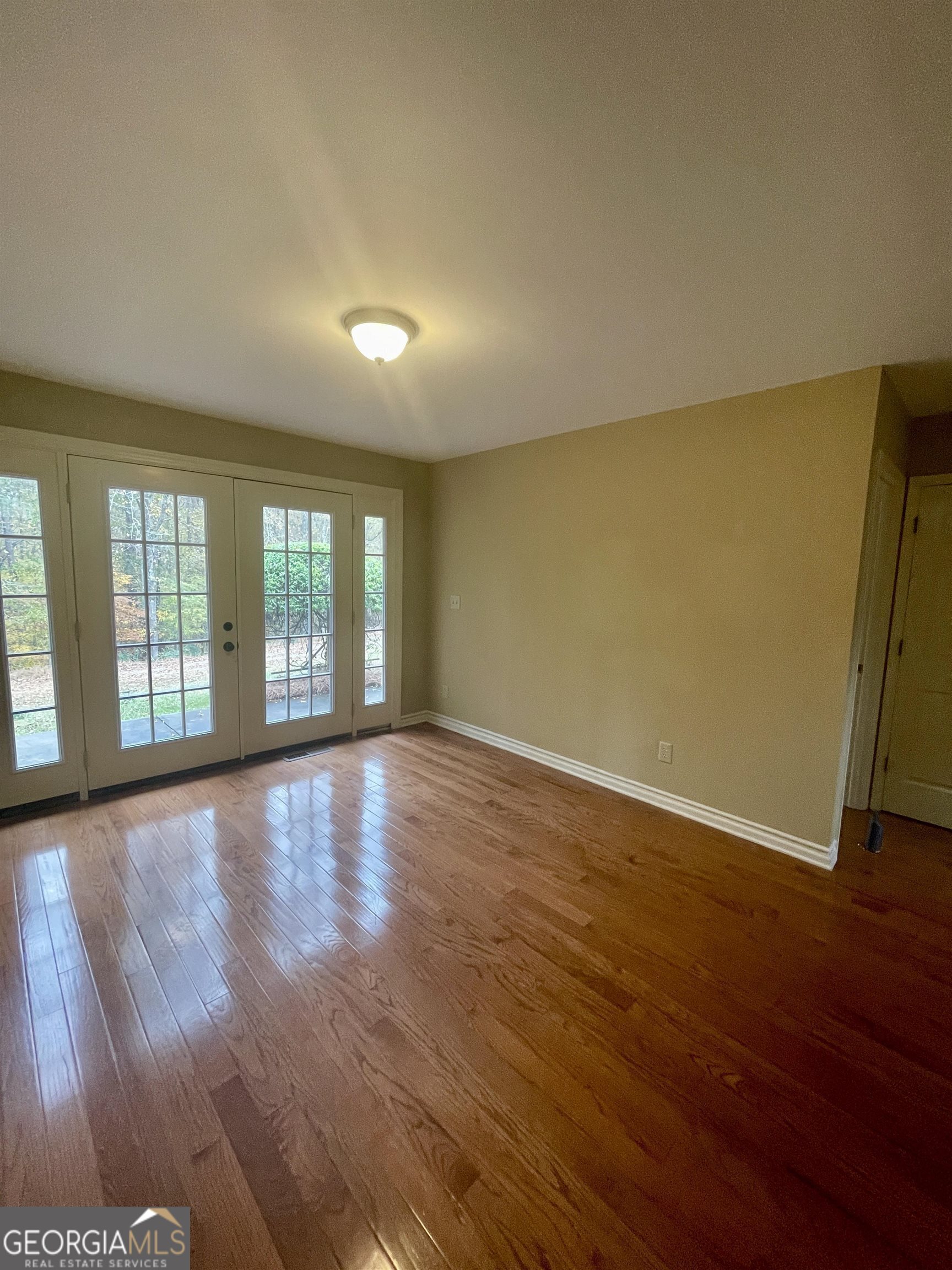 242 Ebenezer Church Road Fayetteville, GA 30215 - Photo 21 of 43 an empty room with wooden floor and windows