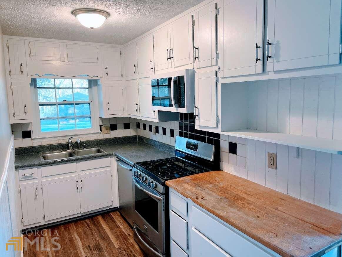 1939 Bonnie Ridge Drive Griffin, GA 30223 - Photo 6 of 23 a kitchen with stainless steel appliances granite countertop a stove a sink and a microwave