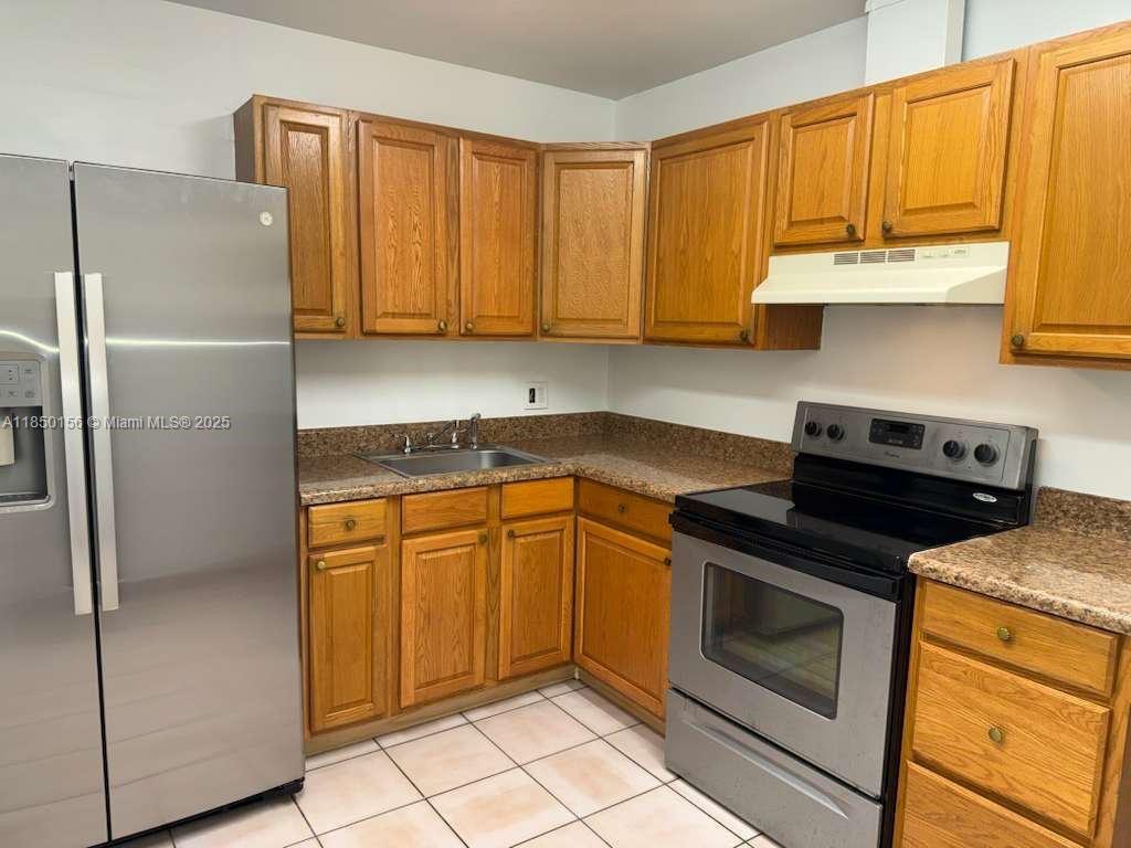 9203 Northwest 38th Drive, Unit 12 Coral Springs, FL 33065 - Photo 1 of 19 a kitchen with stainless steel appliances granite countertop a stove a refrigerator and a cabinets