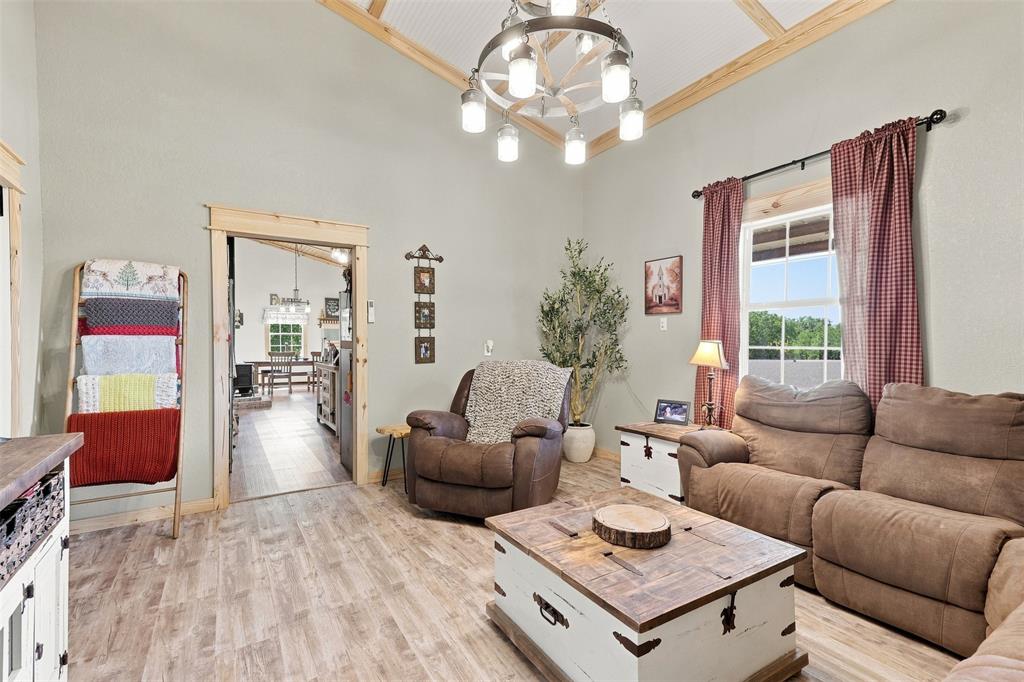 1000 Middleton Road Weatherford, TX 76088 - Photo 8 of 31 Vaulted ceiling with exposed wood beams, wood-finish flooring, and a decorative chandelier