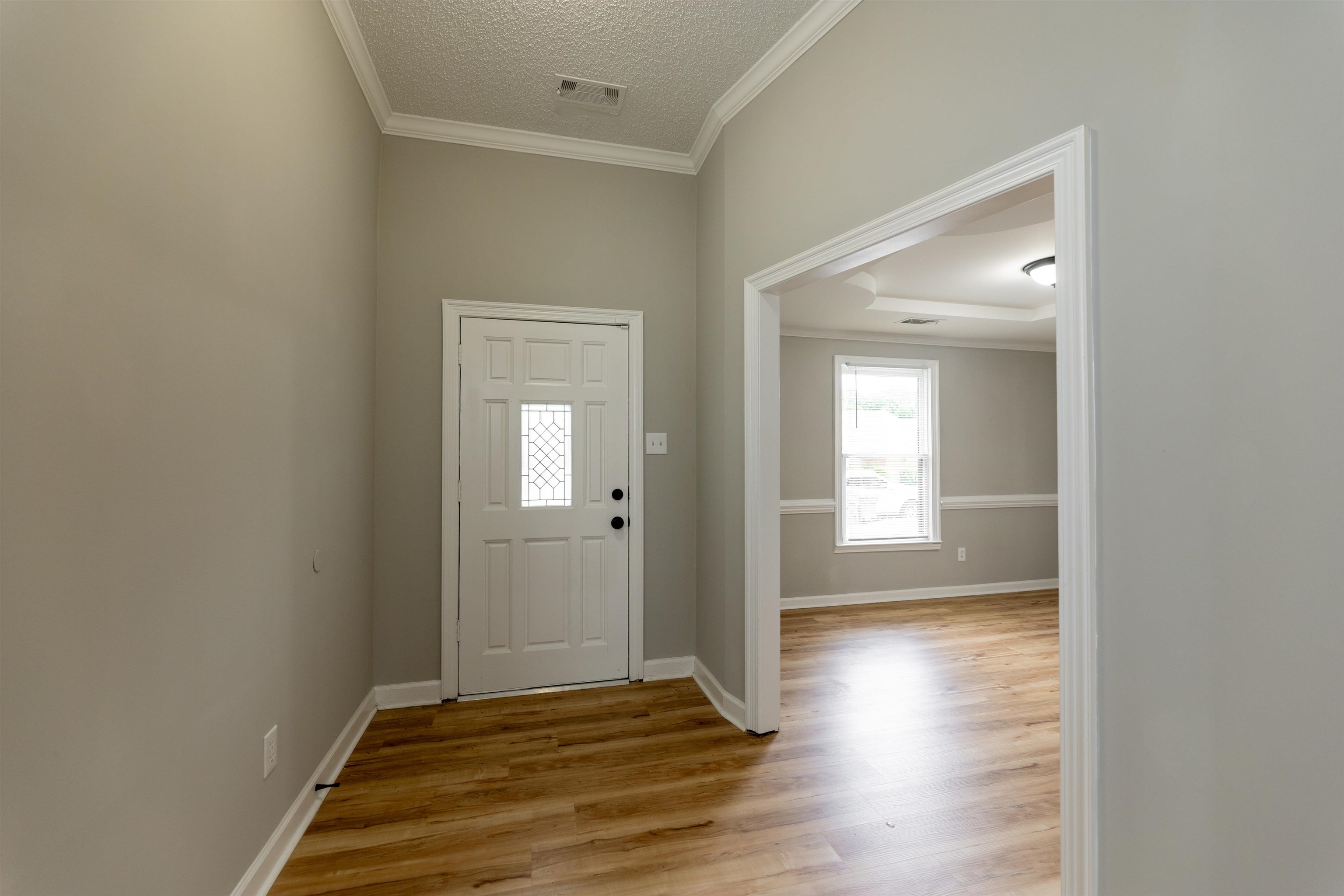 7421 Richmond Road Memphis, TN 38125 - Photo 6 of 39 Entryway featuring wood-finish flooring, a paneled door with decorative glass insert, and crown molding
