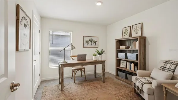 a view of a workspace with furniture and a book shelf