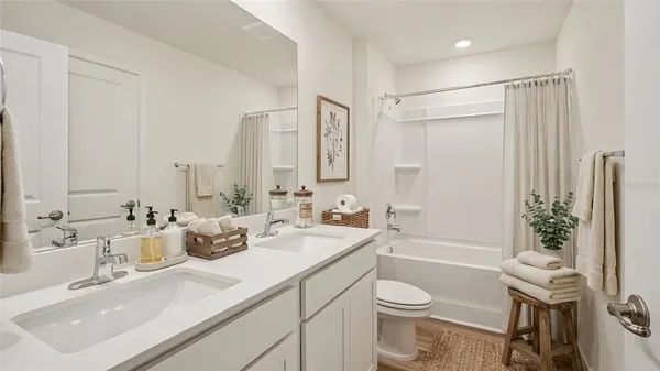 a bathroom with a double vanity sink toilet and shower