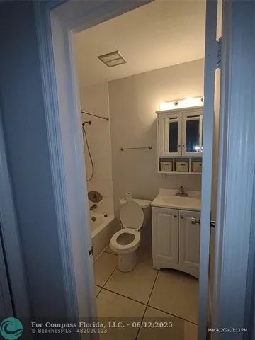 a bathroom with a granite countertop toilet a sink and a mirror