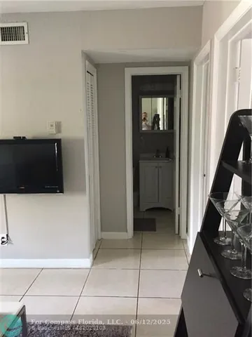 a view of a hallway and a livingroom with furniture