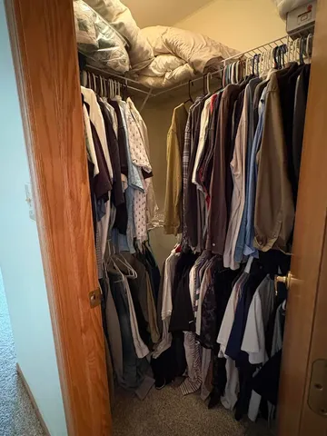a view of walk in closet with clothes and shoes