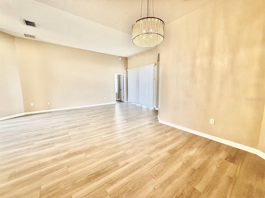 22320 Red Jacket Lane Land O' Lakes, FL 34639 - Photo 6 of 35 a view of empty room with wooden floor and appliances