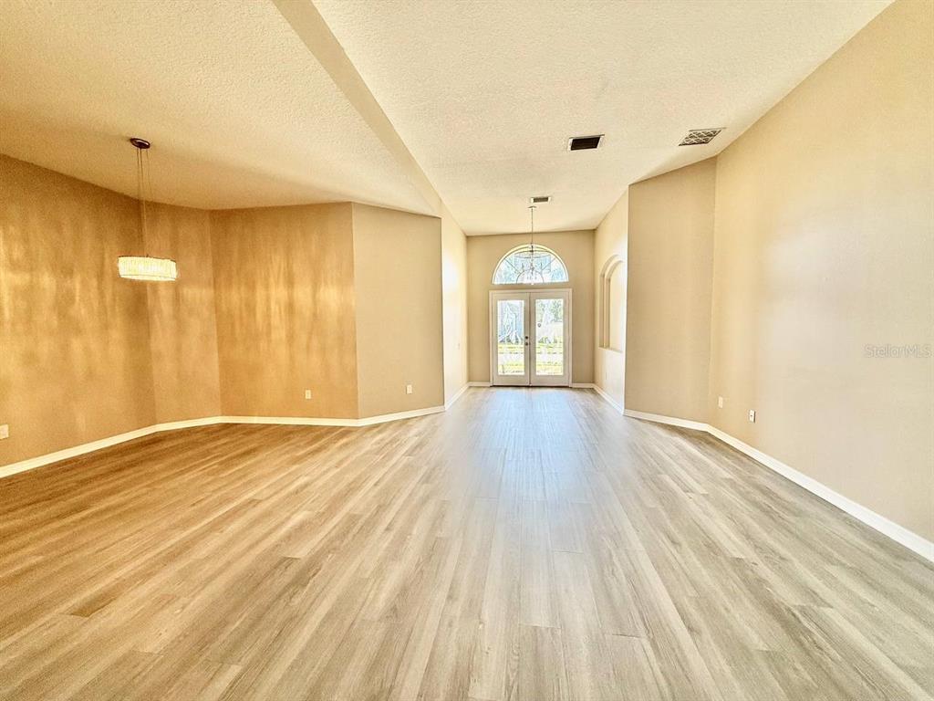 22320 Red Jacket Lane Land O' Lakes, FL 34639 - Photo 7 of 35 a view of an empty room with wooden floor and a window