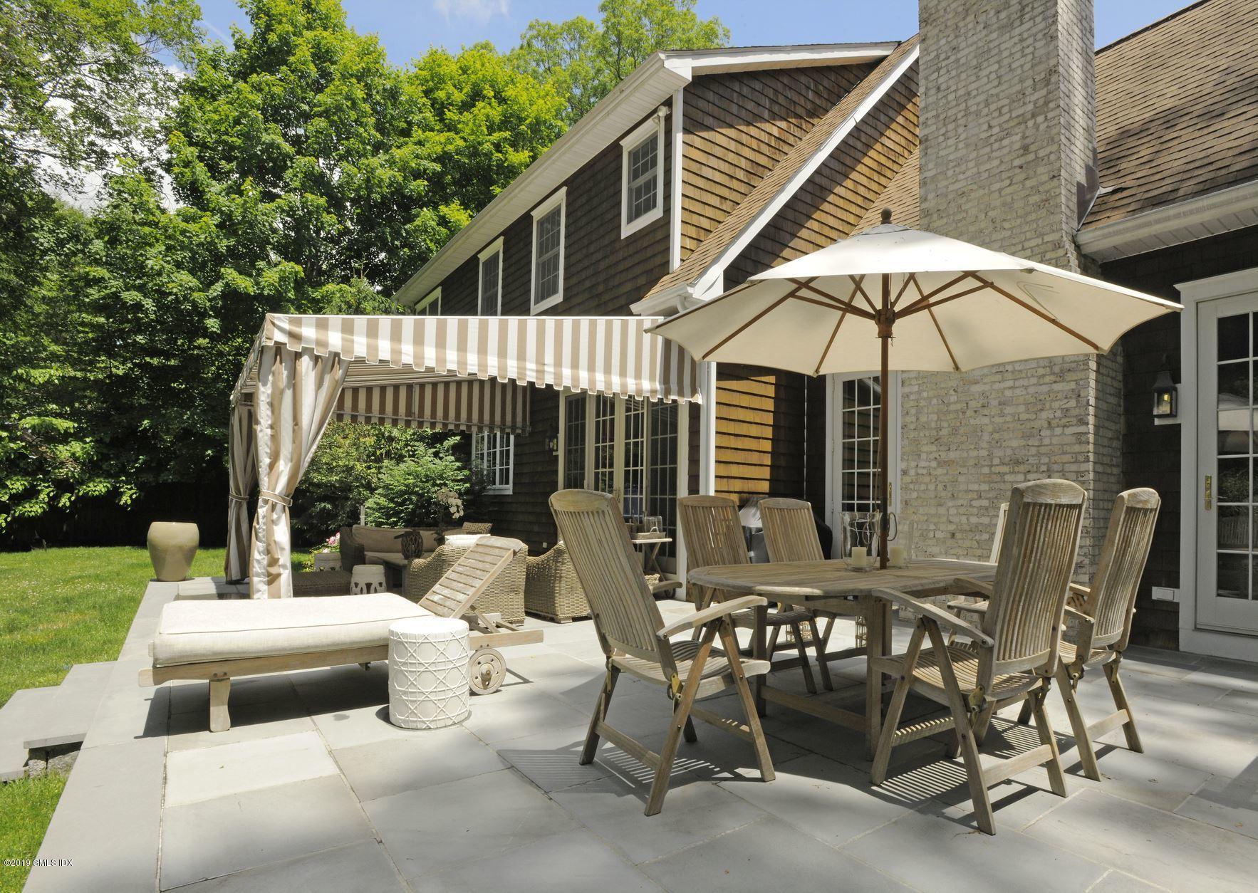 184 Cat Rock Road Cos Cob, CT 06807 - Photo 17 of 25 a view of a patio with a table and chairs under an umbrella