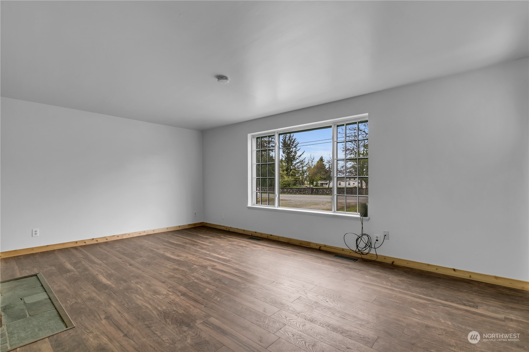 2093 Ryan Road Buckley, WA 98321 - Photo 6 of 25 an empty room with wooden floor and windows