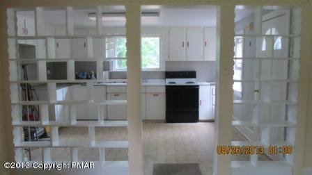 231 Tanite Road Stroudsburg, PA 18360 - Photo 5 of 14 a kitchen with stainless steel appliances kitchen island granite countertop a refrigerator a stove and a sink with wooden floor