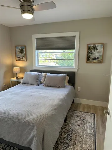 a room with wooden floor and a refrigerator