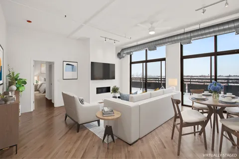 a living room with furniture a flat screen tv and a large window