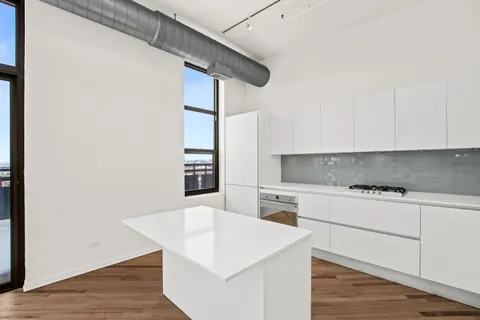 a kitchen with stainless steel appliances white cabinets and wooden floor