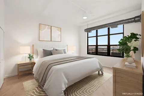 a bedroom with a large bed and a large window