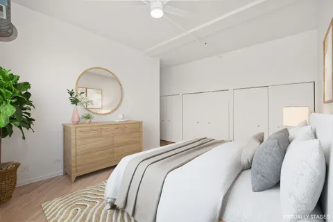 a bedroom with a bed a mirror and a potted plant