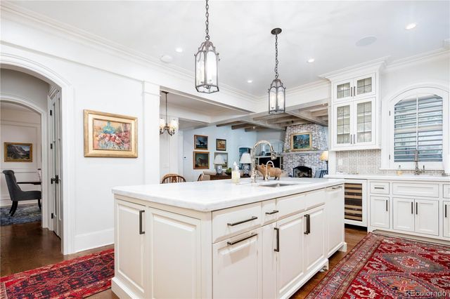 a kitchen that has a lot of white cabinets and wooden floor