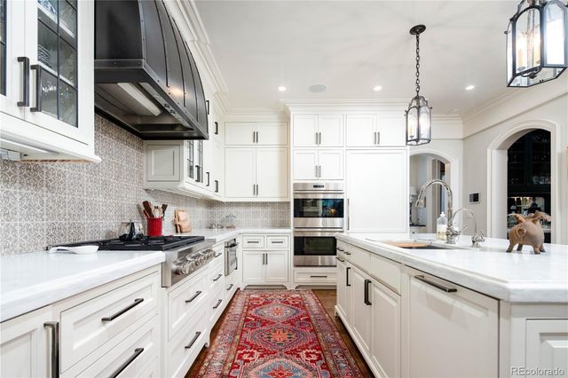 a kitchen with kitchen island granite countertop a sink stainless steel appliances and cabinets