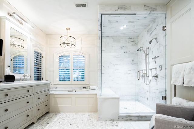 a bathroom with a granite countertop bathtub sink vanity mirror and shower