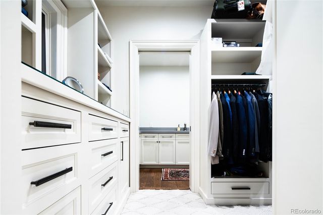a view of walk in closet with clothes and shoes