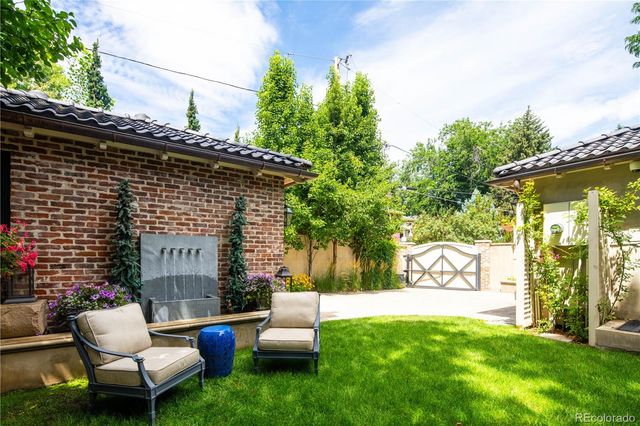 a view of house with backyard and sitting area