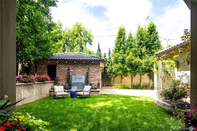 a view of back yard with green space and seating area
