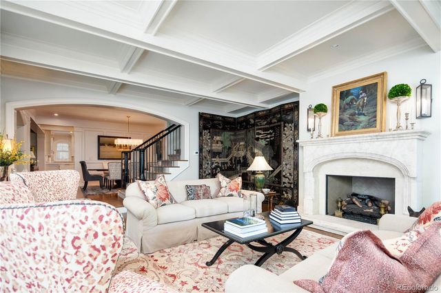 a living room with furniture a fireplace and a large window