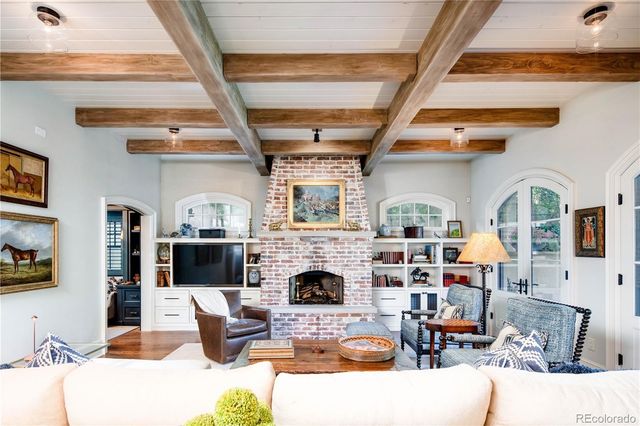 a living room with furniture a fireplace and a flat screen tv